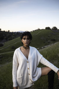 Model in Sweater Stands on Hillside