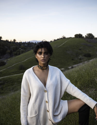 Model in Sweater Stands on Hillside